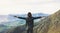 Happy tourist traveler standing on a rock with raised hands, hiker looking to a valley below in trip in spain, hipster young girl