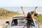 Happy tourists driving a convertible car on vacation