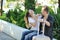 Happy tourists love couple talking outdoor, sitting on a bench in city park