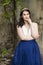 Happy Tranquil Caucasian Lady in Long Blue Dress and Tiara Posing in Authentic Yard Outdoors