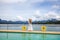 Happy Travel Girl Fun on Wooden Pier with Lake, Rainforest Jungle and Mountains