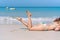 Happy traveler Asian woman in bikini enjoy sunbathing at tropical beach on vacation. Summer on beach concept