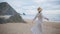 Happy traveler spinning beach on cloudy summer day. Carefree woman enjoying