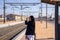 Happy traveler waving goodbye and saying ok with her fingers as she walks along the platform to the platform.