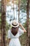 Happy traveler woman standing and looking Pine tree forest, solo tourist in white dress and hat traveling at Pang Oung, Mae Hong