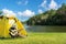 Happy traveler women on vacation camping with tents playing guitar in the forest near river.