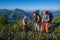 Happy travelers - men and boy stand on the alpine meadow among t