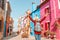 Happy traveller spread his arms at the sight of the stunning cute multicolored houses in the village of Burano, near Venice