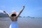 Happy traveller woman in white dress and sea