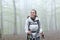 Happy trekker walking in a foggy forest