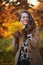 Happy trendy woman in brown coat and yellow hat