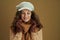 Happy trendy woman in scarf against brown background