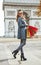 Happy trendy woman in trench coat shopping in Paris, France