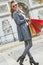 Happy trendy woman in trench coat shopping in Paris, France