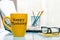 Happy tuesday word on yellow morning coffee cup at blurred home or office background