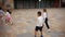 Happy tween girls and boys of different nationalities playing football in schoolyard during break in lessons on warm
