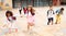 Happy tween schoolchildren with backpacks running to school outdoors