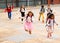 Happy tween schoolchildren with backpacks running to school outdoors