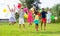 Happy tweenagers with colorful balloons jumping on green lawn