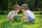 Happy Twin Brothers Playing with Watermelon on Green Grass in Summer Park