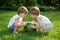 Happy Twin Brothers Playing with Watermelon on Green Grass in Summer Park