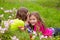 Happy twin sister girls playing whispering ear in meadow