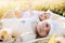 Happy twins sisters newborn babies lying on grass in summer day