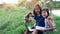 Happy two little child girl learning outdoor by studying online and working on laptop in the green farm field