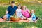 Happy Two Parent Family With Two Daughters On Orange Picnic Blanket