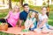 Happy Two Parent Family With Two Daughters On Orange Picnic Blanket