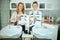 happy two women hairdressers in aprons in modern beauty salon