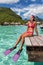 Happy vacation snorkel girl relaxing at overwater bungalow balcony at luxury resort in tahiti. Snorkeling sport activity