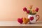 Happy Valentine\\\'s day concept with rose flowers and heart shapes on wooden table over trendy peach color background