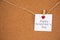 Happy Valentine`s day lettering on white paper pinned with glowing small heart pegs on cork board