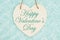 Happy Valentine`s Day message on wood heart shaped plaque with teal plush fabric