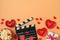 Happy Valentine\\\'s day and romantic movie concept with movie clapper board, heart shapes and popcorn on trendy background.