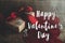 Happy Valentine`s day text on gift box, luxury earrings and red velvet hearts on rustic wood. Card