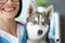 Happy veterinarian woman carry sweet fluffy dog in vet