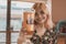 A happy and vibrant young asian woman shows off a cold refreshing glass of beer. At a restaurant, pub or bar during the day