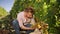 Happy vintner in France examining grapes during vintage. Mature man working