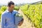 Happy vintner harvesting grapes in vineyard