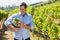 Happy vintner holding harvested grapes in bucket