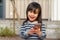 Happy vivacious little girl holding a mobile phone