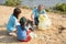 Happy volunteer Asian and children are collecting plastic bottles into garbage box to reduce global warming and environmental