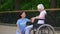 Happy volunteer listening to senior woman sitting wheelchair, old people care