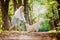 Happy walk with your beloved pet in autumn forest. Young woman in dress is playing with Labrodor Golden Retriever