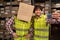 Happy warehouse team with box on head taking a group selfie in workwear. Multiracial logistics employees working