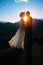 Happy wedding couple staying over the beautiful landscape with mountains