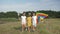 Happy weekend of little friends, joyful kids have fun walking in green meadow with kite on background of forest and blue