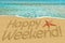 Happy weekend sign on sand and starfish